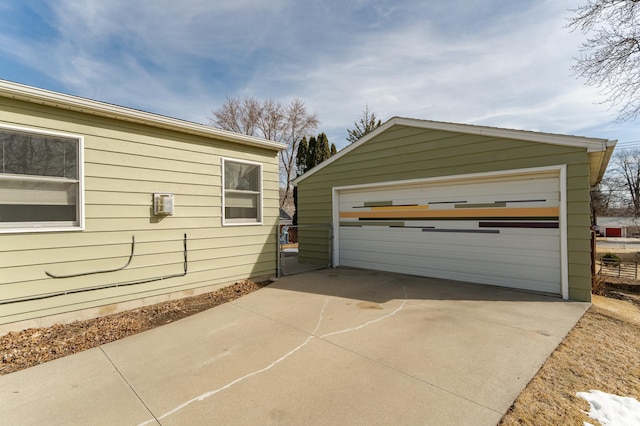 view of property exterior with a detached garage and an outbuilding