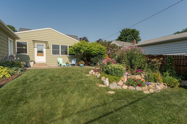 view of yard with fence and entry steps