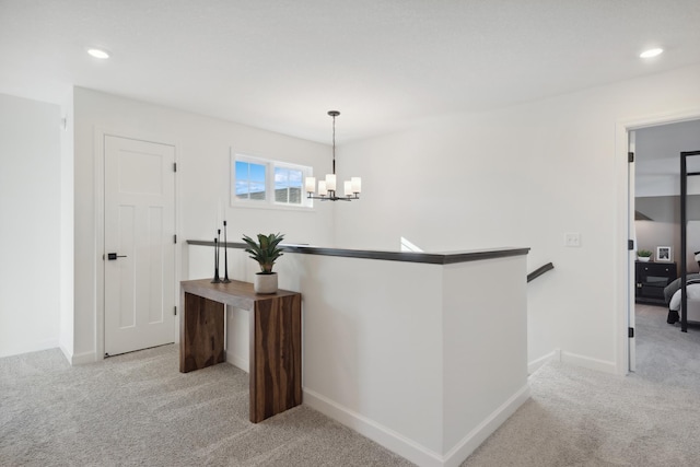 hall featuring baseboards, carpet, an upstairs landing, recessed lighting, and a notable chandelier