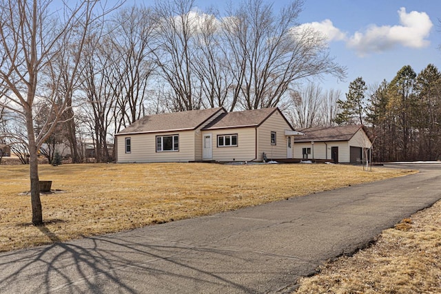 ranch-style house featuring a front lawn and a shingled roof