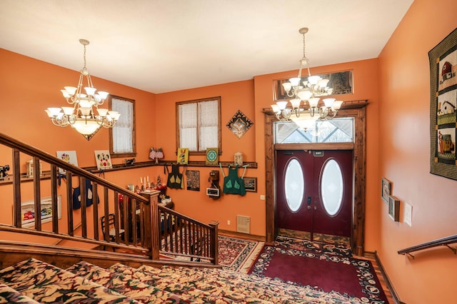 entrance foyer with a notable chandelier, stairs, and baseboards