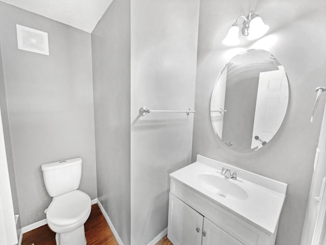 bathroom featuring vanity, wood finished floors, visible vents, baseboards, and toilet