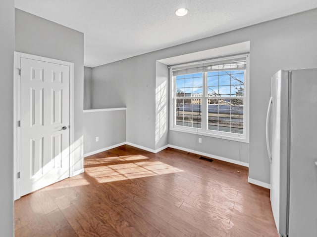 interior space with visible vents, baseboards, and wood finished floors