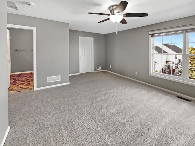 unfurnished bedroom featuring baseboards, visible vents, carpet floors, and a textured ceiling