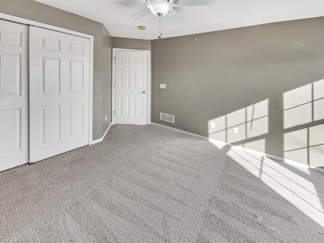 unfurnished bedroom featuring visible vents, a ceiling fan, a closet, carpet floors, and baseboards