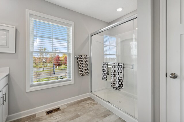 full bath featuring vanity, baseboards, visible vents, recessed lighting, and a shower stall