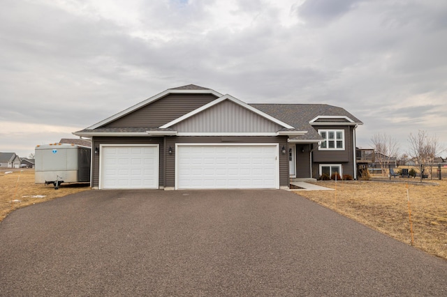 view of front of home with an attached garage, driveway, and roof with shingles