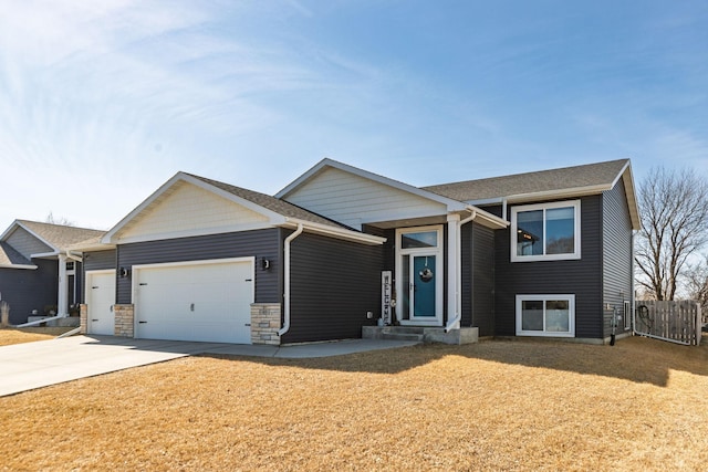 view of front of property featuring an attached garage, fence, and driveway