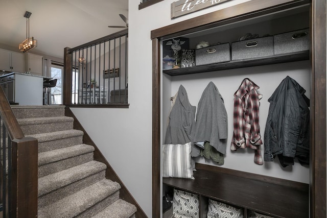 stairway featuring baseboards and a ceiling fan