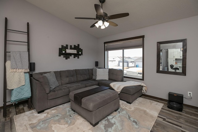 living area with a ceiling fan, lofted ceiling, wood finished floors, and baseboards