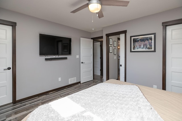 bedroom featuring visible vents, ceiling fan, baseboards, and wood finished floors