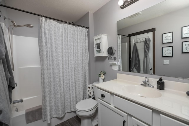 full bathroom featuring vanity, visible vents, shower / tub combo, a textured ceiling, and toilet