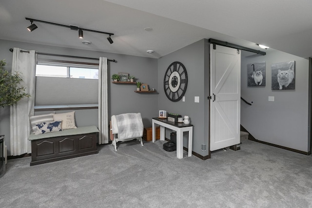 interior space with track lighting, baseboards, carpet, and a barn door