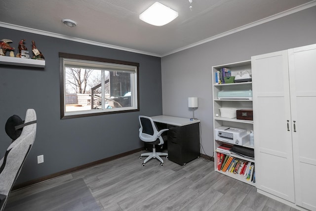 home office featuring crown molding, light wood-style flooring, and baseboards