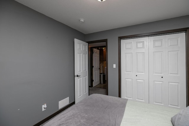 bedroom with visible vents, baseboards, a closet, and carpet flooring