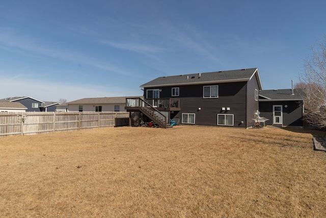 rear view of house featuring stairway, a lawn, a deck, and fence