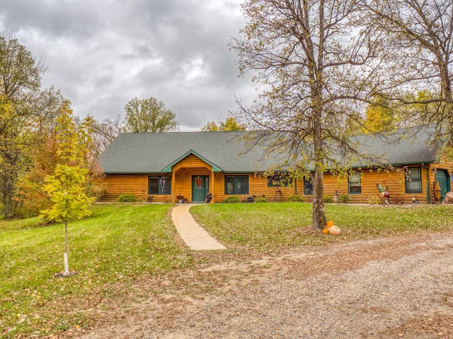 view of front of home featuring roof with shingles and a front yard