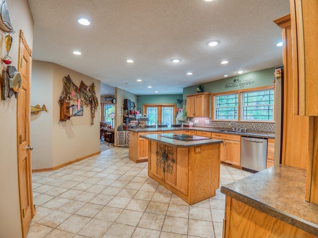 kitchen with a sink, backsplash, a peninsula, light tile patterned floors, and dishwasher