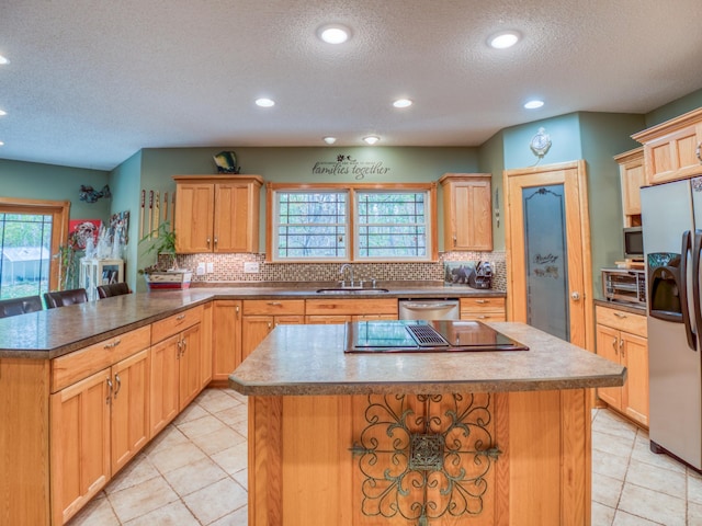 kitchen with a sink, backsplash, appliances with stainless steel finishes, and a center island