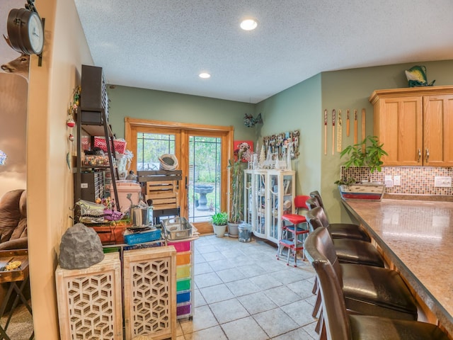 dining area featuring light tile patterned floors, recessed lighting, and a textured ceiling