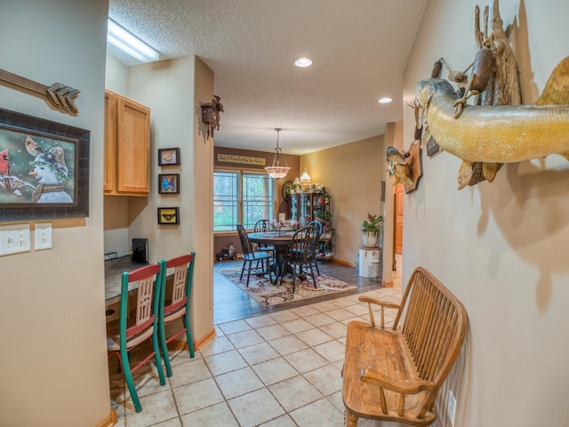 dining area with light tile patterned floors, recessed lighting, a textured ceiling, and baseboards