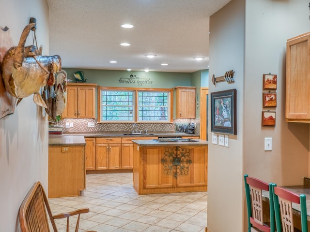 kitchen with light tile patterned floors, recessed lighting, a sink, a textured ceiling, and backsplash