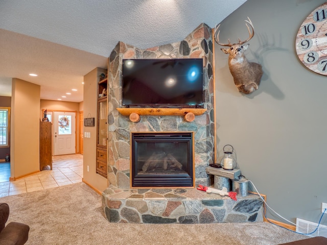 interior details with visible vents, baseboards, carpet floors, a fireplace, and a textured ceiling