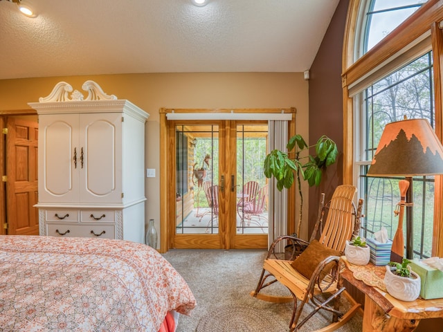 carpeted bedroom featuring access to exterior and a textured ceiling