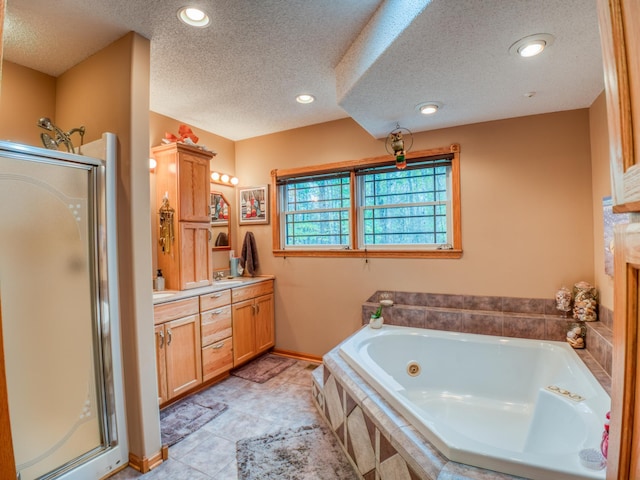 full bathroom featuring a textured ceiling, recessed lighting, a tub with jets, a shower stall, and vanity