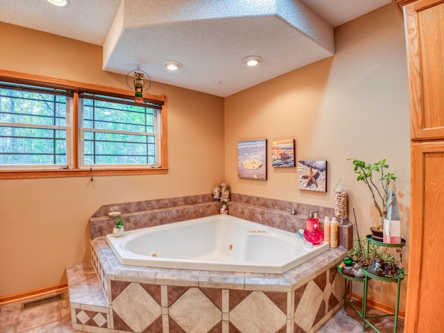 bathroom featuring visible vents, recessed lighting, tile patterned floors, a tub with jets, and a textured ceiling