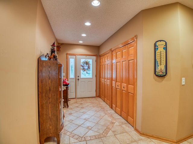 entrance foyer with recessed lighting, baseboards, and a textured ceiling