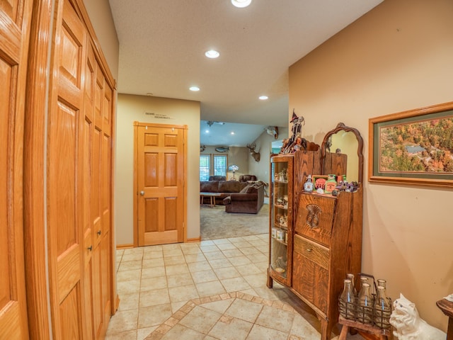 corridor with recessed lighting, baseboards, and vaulted ceiling