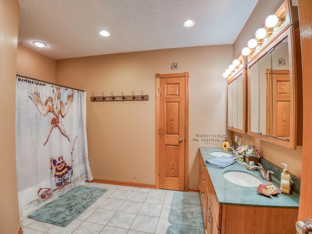 bathroom with a textured ceiling, double vanity, and a sink