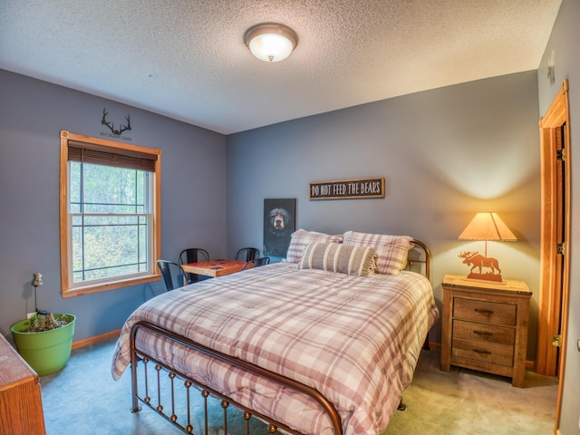 carpeted bedroom featuring a textured ceiling and baseboards