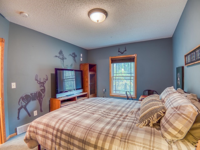 bedroom featuring visible vents, carpet flooring, a textured ceiling, and baseboards