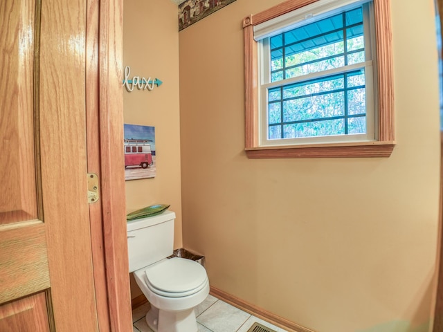 bathroom with tile patterned flooring, toilet, and baseboards