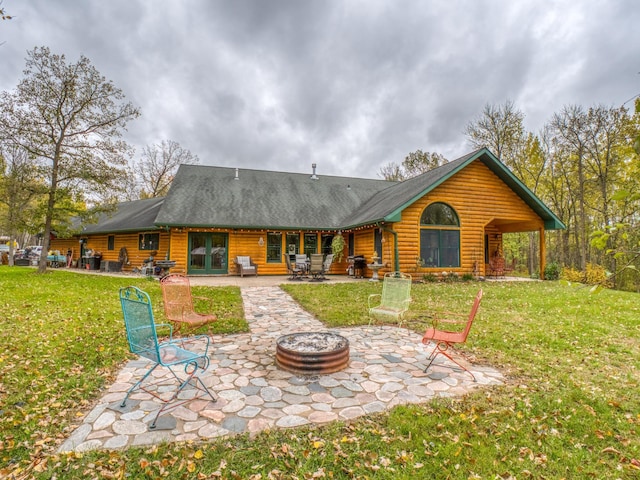 back of property featuring a patio area, an outdoor fire pit, and a yard