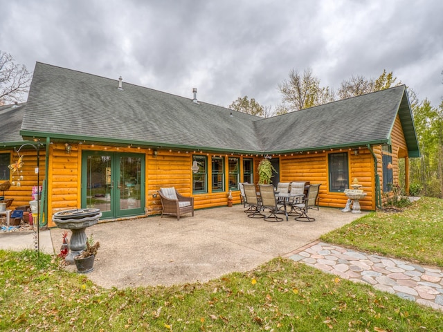 rear view of property featuring a patio area and a shingled roof