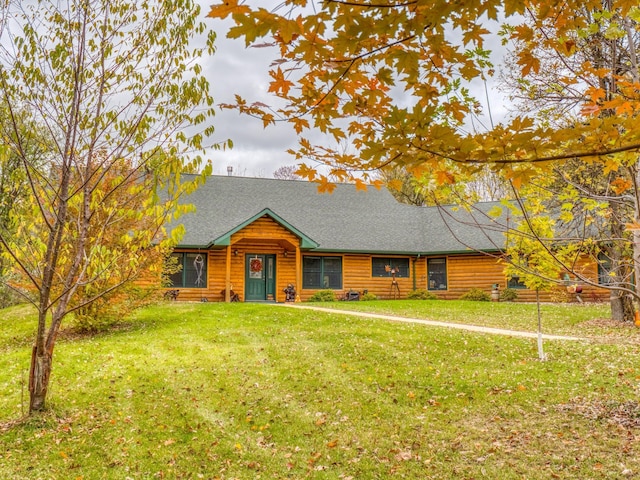 view of front facade featuring a front lawn and a shingled roof