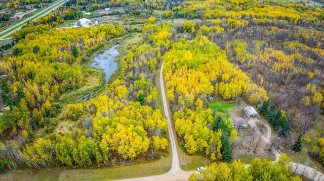 drone / aerial view featuring a view of trees and a water view