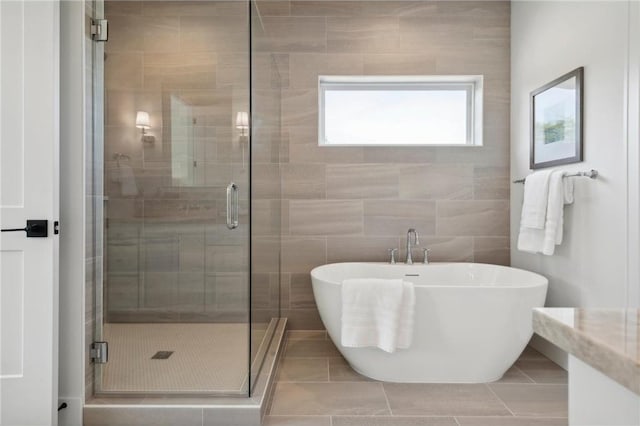 bathroom featuring tile patterned floors, a soaking tub, and a shower stall