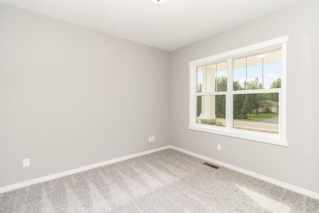 spare room featuring visible vents, carpet flooring, and baseboards