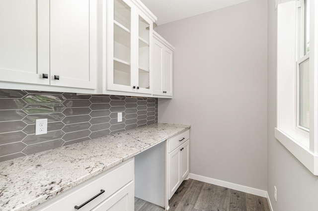 kitchen featuring wood finished floors, glass insert cabinets, baseboards, and white cabinets