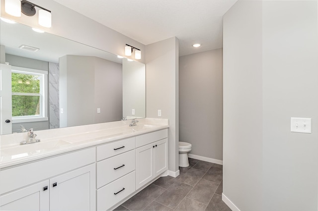 full bathroom featuring double vanity, visible vents, baseboards, and a sink