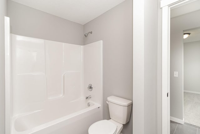 full bathroom with baseboards, toilet, bathing tub / shower combination, and tile patterned flooring