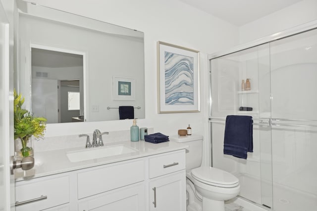 full bathroom featuring vanity, a shower stall, toilet, and visible vents