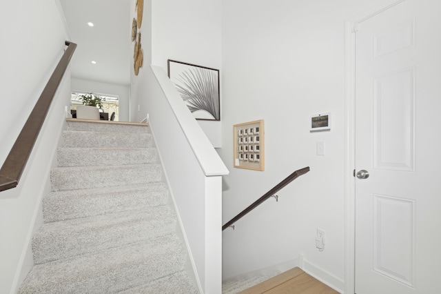 stairway with recessed lighting and baseboards