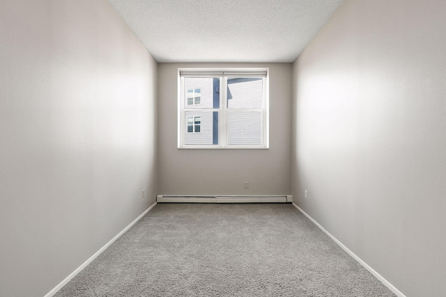 unfurnished room featuring a baseboard heating unit, baseboards, a textured ceiling, and carpet flooring