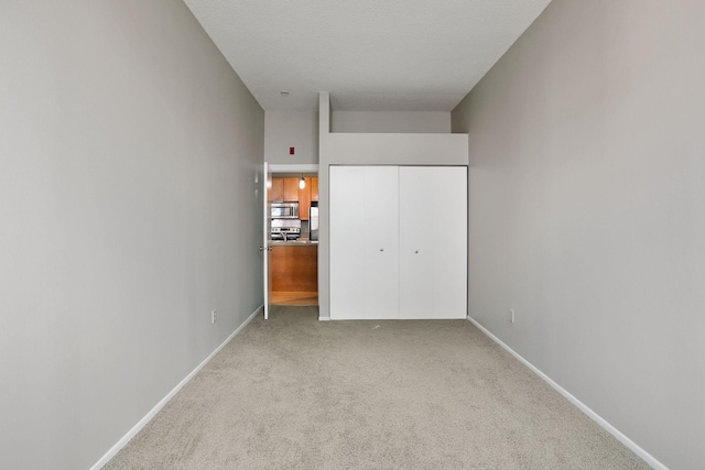 unfurnished bedroom featuring a closet, baseboards, and carpet floors