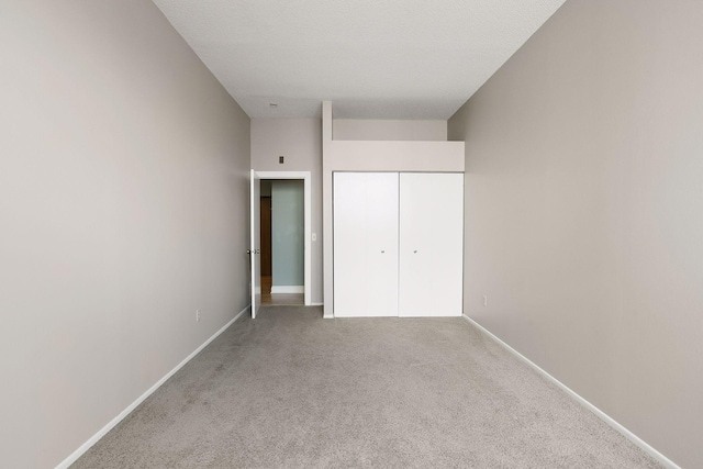 unfurnished bedroom featuring baseboards, carpet floors, and a closet